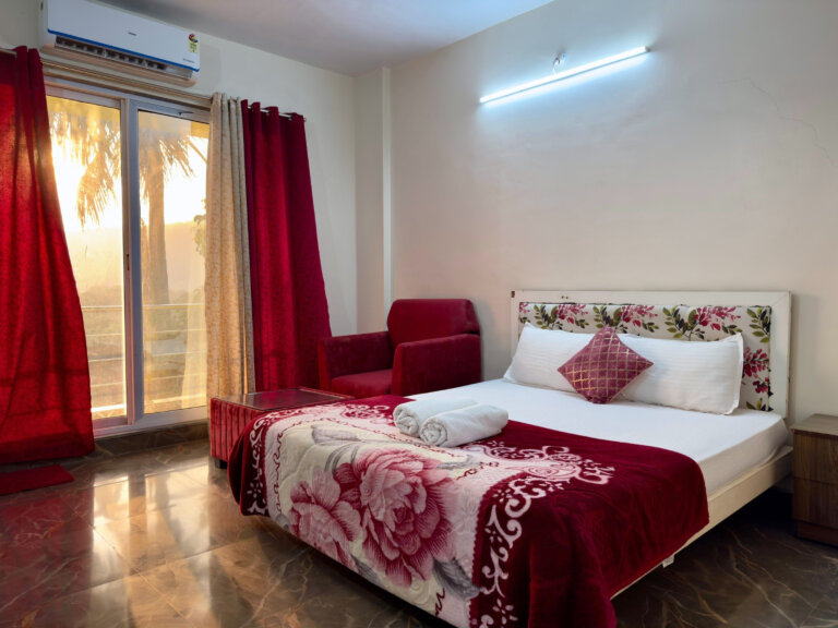 Red-accent bedroom in the evening light at NB Nature Stay