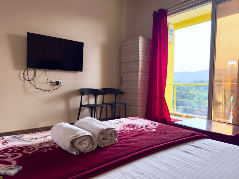 Red-accent bedroom with television and balcony doors at NB Nature Stay